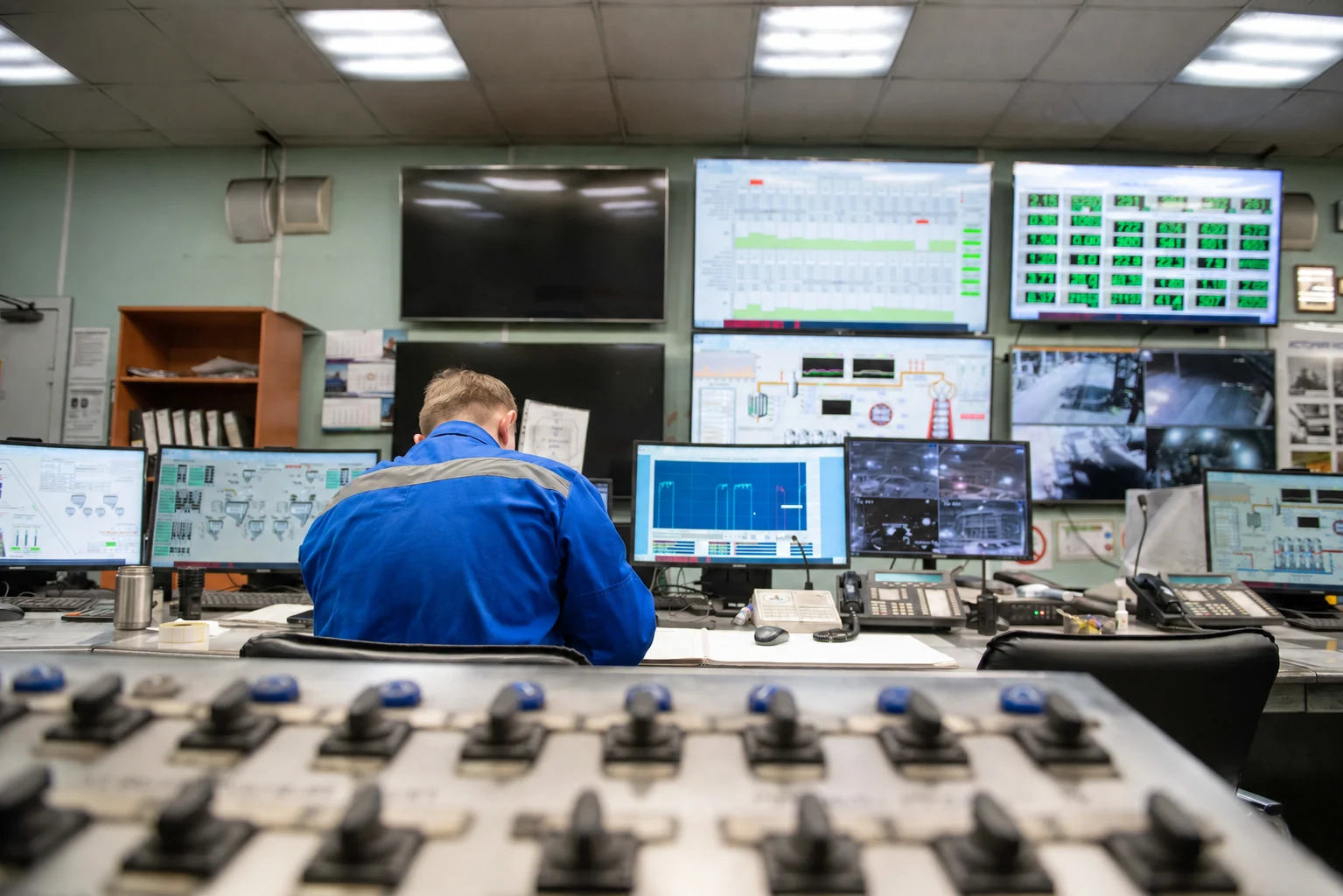 Operator monitorujący procesy na ekranach w centrum kontroli